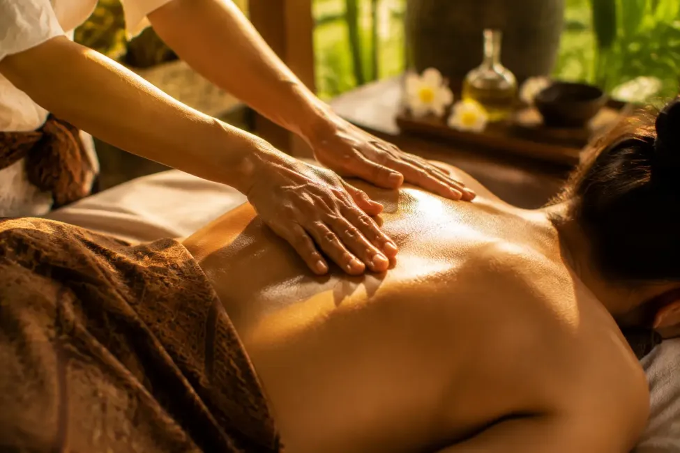 massage home service in sanur with shoulders and back being gently massaged with oil under soft indoor lighting in villa sanur ,bali